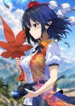  1girl black_bow black_bowtie black_feathers black_hair black_skirt blue_sky blurry blush bow bowtie breasts camera cloud collared_shirt commentary_request day depth_of_field falling_feathers feathers hat hauchiwa highres holding holding_camera kitaura_kasumi large_breasts leaf_print maple_leaf_print missing_wings pointy_ears pom_pom_(clothes) puffy_short_sleeves puffy_sleeves red_eyes red_hat shameimaru_aya shirt short_sleeves skirt sky smile solo tokin_hat touhou white_shirt 