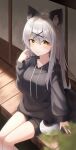  1girl absurdres animal_ears bini_(bini_owo) black_hoodie black_shorts breasts fox fox_ears fox_tail grey_hair highres hood hoodie japanese_house long_hair looking_at_viewer original shorts silver_hair smile solo tail white_hair yellow_eyes 