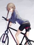  1girl absurdres amane_suzuha arm_support ass bangs bare_legs bicycle bike_shorts blue_jacket braid brown_hair closed_mouth eyebrows_visible_through_hair feet_out_of_frame from_behind gradient gradient_background grey_background ground_vehicle highres jacket leaning_forward long_sleeves looking_at_viewer looking_back mac_star smile solo steins;gate track_jacket twin_braids yellow_eyes 