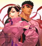  1boy 1girl alternate_costume belt black_hair chun-li collarbone commentary_request double_bun hair_ribbon headband high_collar looking_at_viewer mita_chisato official_alternate_costume parted_lips pink_ribbon red_headband ribbon ryu_(street_fighter) serious smile street_fighter street_fighter_v tan thick_eyebrows upper_body zipper_pull_tab 