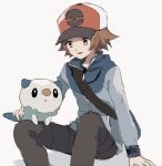  1boy bag baseball_cap blue_jacket brown_eyes brown_hair commentary_request grey_pants hat hilbert_(pokemon) jacket long_sleeves male_focus messenger_bag open_mouth oshawott pants poke_ball_print pokemon pokemon_(creature) pokemon_(game) pokemon_bw red_headwear short_hair shoulder_bag smile zges 