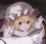  1girl bangs blonde_hair flandre_scarlet happiness_lilys hat hat_ribbon highres laevatein_(touhou) looking_at_viewer lying mob_cap on_stomach one_side_up open_mouth red_eyes red_ribbon red_vest ribbon shirt short_hair short_sleeves solo touhou upper_body vest white_headwear white_shirt wings wrist_cuffs 