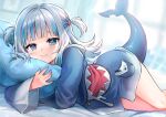  1girl bangs blue_eyes blue_hoodie blunt_bangs commentary feet_out_of_frame fish_tail gawr_gura hololive hololive_english hood hoodie indoors iro_178 long_hair looking_at_viewer lying multicolored_hair object_hug on_side pillow pillow_hug shark_tail silver_hair smile solo streaked_hair symbol-only_commentary tail twitter_username two_side_up virtual_youtuber 