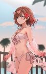  1girl absurdres bikini blurry blurry_background blurry_foreground blush collarbone commentary cowboy_shot depth_of_field eyewear_on_head flower groin hair_flower hair_ornament halterneck heart heart-shaped_eyewear highres higuchi_madoka idolmaster idolmaster_shiny_colors looking_away midriff mole mole_under_eye navel nonbire outdoors palm_tree railing red_eyes red_hair shawl side-tie_bikini solo swimsuit symbol-only_commentary thighs tree 