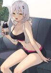  1girl :d bare_arms bare_shoulders black_shorts breasts cleavage collarbone commentary_request couch crop_top cup grey_hair hair_ornament hairclip highres holding itohana long_hair looking_at_viewer medium_breasts micro_shorts midriff navel on_couch original shorts sitting sleeveless smile solo sports_bra stomach sweat thighs towel towel_around_neck x_hair_ornament yellow_eyes 