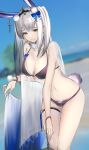  1girl absurdres animal_ears bangs beach bikini black_bikini blue_bow blunt_bangs blurry blurry_background bow breasts chain cleavage commentary_request day ear_ornament earrings eugle_na extra_ears fur_collar hair_behind_ear hair_ornament highres jewelry kaavi large_breasts leaning_forward long_hair looking_at_viewer mahjong_soul navel ocean outdoors pom_pom_(clothes) rabbit_ears rabbit_girl rabbit_tail silver_hair sky solo standing swimsuit tail thigh_strap veil water x_hair_ornament yellow_eyes 