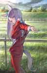  1girl absurdres animal_ears day feet_out_of_frame fence from_side grass grin head_tilt highres horse_ears horse_girl horse_tail long_hair looking_at_viewer mejiro_mcqueen_(umamusume) outdoors purple_eyes purple_hair red_track_suit sky smile solo standing stretch sun tail tentsuu_(tentwo) umamusume 