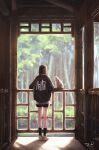  1girl architecture black_hair black_shorts black_socks black_sweater cat commentary day english_commentary from_behind highres light_particles long_sleeves original railing razaras shadow shoes short_hair shorts signature socks solo standing sweater tree white_shoes wide_shot 