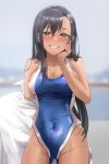  1girl black_hair blue_swimsuit blurry blurry_background breasts brown_eyes cleavage competition_swimsuit cowboy_shot dark-skinned_female dark_skin drive_shot fang grin hair_ornament hairclip highres ijiranaide_nagatoro-san looking_at_viewer medium_breasts nagatoro_hayase one-piece_swimsuit smile solo swimsuit tan towel two-tone_swimsuit 