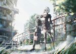  1boy 1girl 2b_(nier:automata) 9s_(nier:automata) against_railing arm_up black_blindfold black_dress black_hairband black_thighhighs blindfold boots breasts choker city clothing_cutout commentary_request covered_eyes dress feather-trimmed_sleeves film_grain from_below gloves grass hairband high_heels highres nier:automata nier_(series) puffy_sleeves railing ruins shikan short_hair shorts signature thigh_strap thighhighs white_hair 
