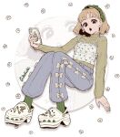  1girl artist_name blonde_hair blue_pants cellphone commentary crocs denim floral_background full_body green_hairband green_socks green_sweater hairband highres jeans long_sleeves looking_at_viewer open_mouth original pants phone sandals shirt short_hair sitting smartphone socks solo sweater untranslatable_commentary wachichi_3 white_shirt zoom_layer 