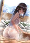  1girl ass blush breasts brown_hair commentary_request dutch_angle green_eyes hair_between_eyes highres long_hair looking_back medium_breasts mountain onsen original outdoors parted_lips partially_submerged ripples see-through sideboob sky snowing solo tree wet wet_towel yukemuriganmo 
