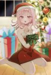  1girl :o bare_shoulders barefoot blush bow box christmas_tree commentary_request danganronpa_(series) danganronpa_2:_goodbye_despair dress gift gift_box green_bow green_ribbon hands_up hat highres indoors medium_hair nanami_chiaki no_hair_ornament pink_eyes pink_hair red_dress ribbon santa_costume santa_dress santa_hat solo tengai_(xmxmddnnz) wooden_floor 
