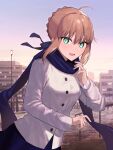  1girl ahoge artoria_pendragon_(fate) bangs blonde_hair blue_scarf braid braided_bun building coat duffel_coat dutch_angle eyebrows_visible_through_hair fate/stay_night fate_(series) french_braid green_eyes hair_ornament hair_ribbon happy highres long_sleeves looking_at_viewer open_mouth outdoors park ribbon saber scarf short_hair skirt sky smile solo standing tamitami 