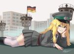  1girl aqua_eyes belt berlin_wall black_footwear black_necktie blonde_hair boots brown_belt building east_german east_german_flag fang feet_out_of_frame flag from_side giant giantess grey_jacket grey_skirt grey_sky hat highres jacket long_hair looking_at_viewer lying military military_uniform miniskirt mole mole_under_eye necktie on_stomach original outdoors peaked_cap pleated_skirt shirt signature skirt smile solo teaparty teeth thighhighs tower uniform white_legwear white_shirt 