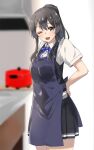  1girl apron black_apron black_hair black_skirt black_vest blue_neckwear blue_ribbon blurry blurry_background brown_eyes commentary_request cowboy_shot depth_of_field dress_shirt highres kantai_collection kitchen long_hair looking_at_viewer neck_ribbon one_eye_closed oyashio_(kancolle) pleated_skirt ponytail ribbon rice_cooker shirt short_sleeves skirt solo standing vest wasumi_kei white_shirt 