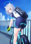  1girl animal_ear_fluff animal_ears aqua_eyes ass bag bangs bicycle bike_jersey bike_shorts blue_archive blue_shorts blurry blurry_background blush building cat_ears clothes_writing cross_hair_ornament duffel_bag evanstan gloves green_gloves grey_hair ground_vehicle hair_intakes hair_ornament halo highres looking_at_viewer looking_back medium_hair mismatched_pupils open_mouth outdoors riding_bicycle shiroko_(blue_archive) shoes short_sleeves shorts solo 