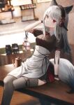  1girl absurdres animal_ears apron arknights arm_support bangs black_legwear black_skirt blurry blurry_background closed_mouth coffee_beans coffee_maker_(object) coffee_pot crossed_legs eyebrows_visible_through_hair flippy_(cripine111) fox_ears fox_girl fox_tail frostleaf_(arknights) hair_ornament hand_on_headphones head_tilt headdress headphones highres leg_garter light_blush long_hair looking_at_viewer miniskirt puffy_short_sleeves puffy_sleeves red_eyes short_sleeves sitting sitting_on_table skirt solo table tail thighhighs waist_apron white_hair wristband zettai_ryouiki 