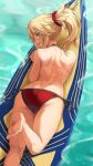  1girl ass back barefoot bikini blonde_hair braid fang fate/grand_order fate_(series) feet green_eyes highres leg_up legs looking_at_viewer looking_back lying mordred_(fate) mordred_(swimsuit_rider)_(fate) mordred_(swimsuit_rider)_(first_ascension)_(fate) on_stomach ponytail prydwen_(fate) red_bikini red_scrunchie scrunchie side-tie_bikini_bottom smile soles surfboard swimsuit tan tanlines toenails toes tonee topless water 