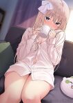  1girl bangs bare_legs blonde_hair blue_eyes blurry blurry_background blush borrowed_garments breasts cleavage coffee_mug commentary_request couch cup curtains cushion dress_shirt eyebrows_visible_through_hair hair_between_eyes hair_ribbon holding holding_cup indoors long_hair looking_at_viewer morning mug navel nekokobushi original ribbon shirt sitting small_breasts solo thighs white_shirt 