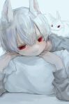  1boy absurdres animal animal_ears animal_on_back closed_mouth hair_between_eyes highres hzk_(user_kemd2843) long_sleeves looking_at_viewer lying on_stomach original pillow pillow_grab rabbit_boy red_eyes shirt short_hair smile white_background white_hair 