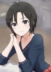  1girl antenna_hair black_hair blurry blurry_background elbows_on_table grey_eyes hair_between_eyes highres idolmaster idolmaster_(classic) idolmaster_2 kikuchi_makoto looking_at_viewer mogskg own_hands_together short_hair solo sweater upper_body v-neck 