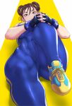  1girl abs anagumasan blue_bodysuit bodysuit breasts brown_eyes brown_hair chun-li covered_abs cross-laced_footwear double_bun exercise fingerless_gloves gloves hair_ribbon highres lying muscular muscular_female on_back ribbon skin_tight solo street_fighter street_fighter_zero_(series) stretch yellow_ribbon 