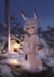  1girl absurdres alternate_hairstyle ass ayanami_(azur_lane) azur_lane bangs bare_back bare_shoulders breasts commentary_request eyebrows_visible_through_hair fence hair_between_eyes hair_bun hair_ornament hairclip headgear highres holding holding_towel in_water lantern long_hair looking_at_viewer midriff night night_sky nipples nude onsen orange_eyes sideboob sidelocks silver_hair sky solo star_(sky) starry_sky steam towel tree wet wooden_fence xdp_(dx19291005) 