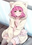  1girl absurdres ahoge animal_hood bangs between_legs blush cat_hood cat_paw commentary_request eyebrows_visible_through_hair glass grey_legwear hand_between_legs highres hood hooded_jacket jacket kamesys light_brown_jacket long_sleeves looking_at_viewer love_live! love_live!_nijigasaki_high_school_idol_club open_clothes open_jacket pink_hair pink_sweater pleated_skirt short_hair sitting skirt smile solo sweater tennouji_rina thighhighs turtleneck white_skirt yellow_eyes 