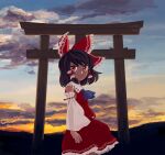  1girl arms_at_sides ascot black_hair blue_ascot bow closed_mouth cloud cowboy_shot detached_sleeves frilled_bow frilled_hair_tubes frills from_side hair_bow hair_tubes hakurei_reimu looking_at_viewer looking_to_the_side medium_hair outdoors red_bow red_eyes red_skirt red_vest ribbon_trim sidelocks skirt skirt_set sky smile solo sunset torii touhou vest white_sleeves wide_sleeves you_taira 