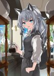  1girl animal_ear_fluff animal_ears barista black_vest blue_eyes buttons coffee commentary cowboy_shot fang fox_ears fox_girl fox_tail from_side grey_hair hand_on_own_hip highres holding_coffee_pot indoors kamiyoshi_rika light_blush long_hair looking_at_viewer open_mouth original ponytail shirt smile solo standing tail vest white_shirt wing_collar 